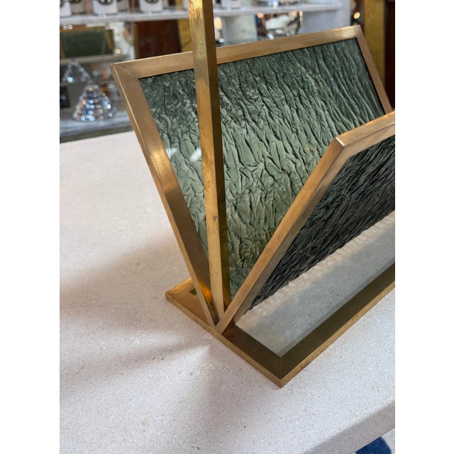 Sculptural mid-century Italian magazine holder featuring a geometric brass frame paired with textured green plexiglass...