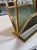 Sculptural mid-century Italian magazine holder featuring a geometric brass frame paired with textured green plexiglass...