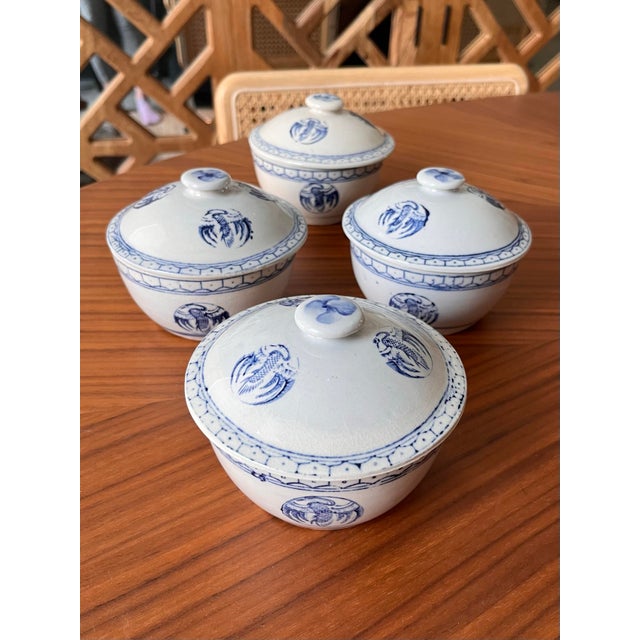 Four beautiful blue and white, individual, lidded rice bowls decorated with cranes and a pansy lid button.
