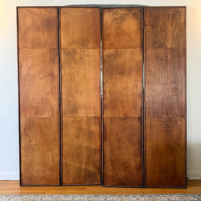 Vintage tooled leather four-panel folding screen featuring richly embossed floral and foliate decoration surrounding inset...