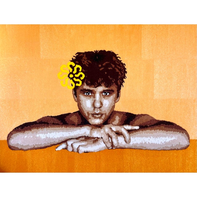 A face looks directly back at the viewer, chin resting on folded arms, a single yellow flower tucked into the hair. There...
