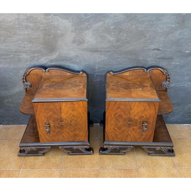 Pair of European Art Deco Nightstands, circa 1940s. Crafted in walnut veneer with striking symmetrical grain patterns,...