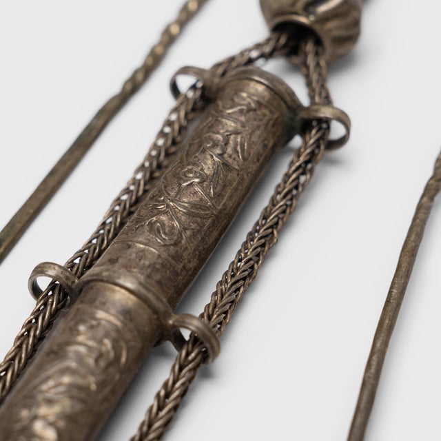 This curious chain of charms and tools is a traditional Chinese grooming kit, intricately worked of silver alloy with...
