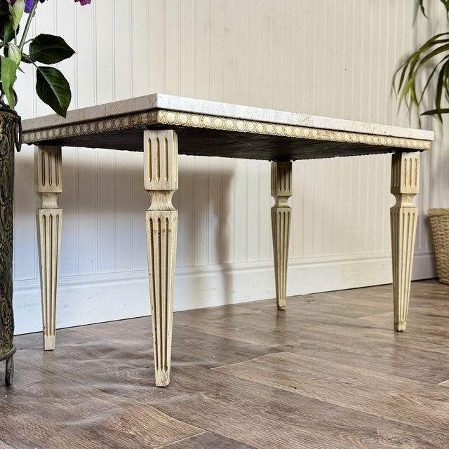 Vintage Neoclassical Revival side table featuring a travertine stone top and an ivory base with fluted legs, egg-and-dart...