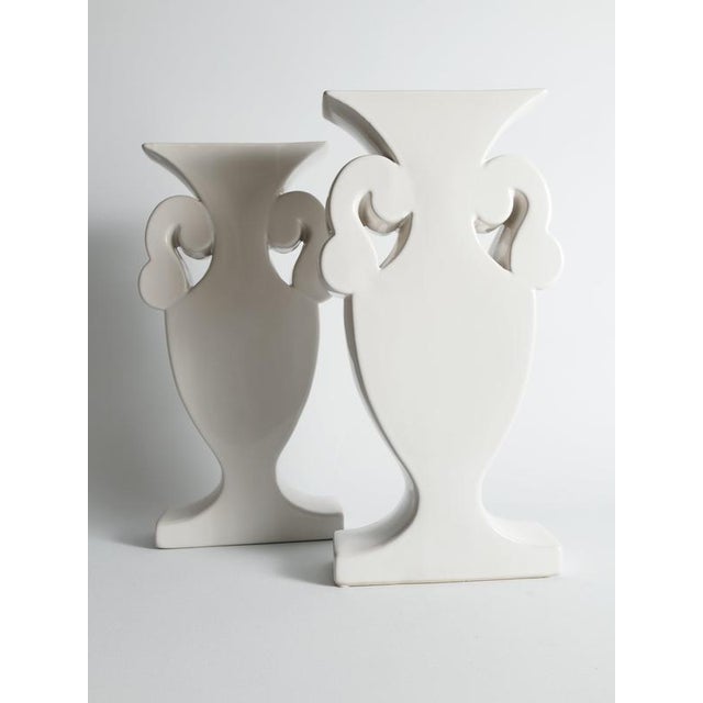 A striking pair of Postmodern flattened ceramic urn vases from the 1980s, finished in a clean, glossy milk-white glaze....