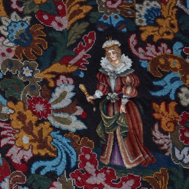 An antique 19th-century pictorial needlepoint tapestry, unsigned, showcasing a detailed figural scene. The central motif...