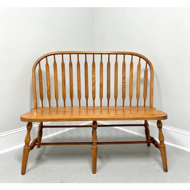 A handcrafted Windsor bench in the Rockford style by Amish craftsmen. Solid oak, bowback, cattail spindles, solid seat,...