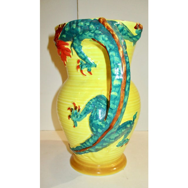 Bright yellow glazed pitcher with red and green dragon forming the handle and wrapping around the body. English makers...