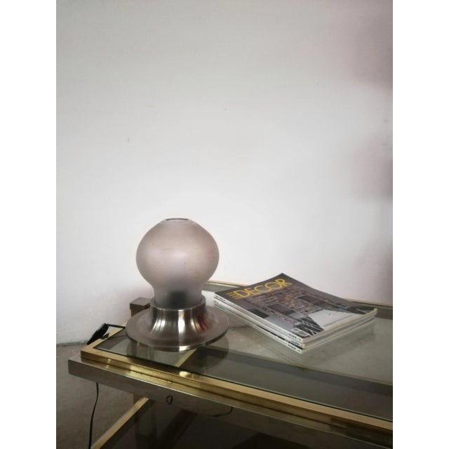 Table lamp composed of a massive metal base on which it houses a glass with a mushroom shape. The diffuser made of etched...
