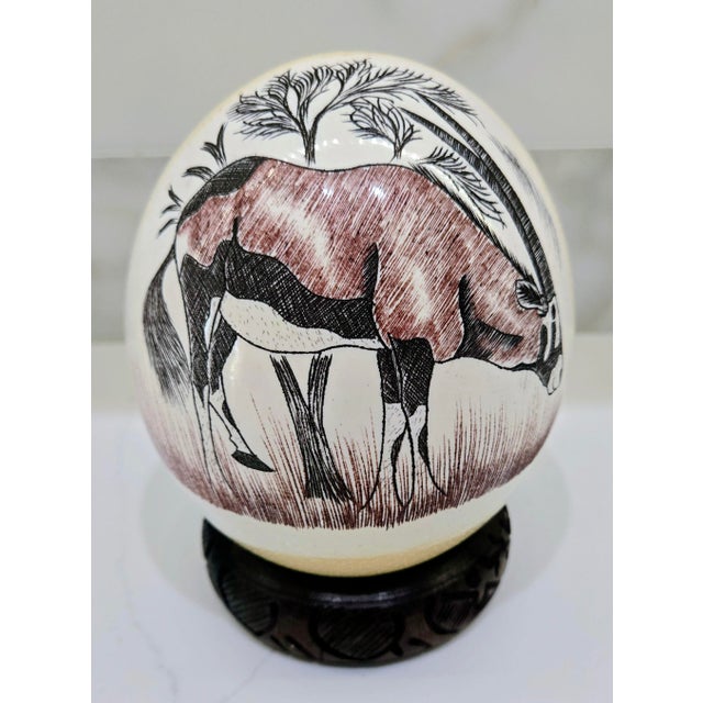 This mid-century scrimshaw-style South African ostrich egg features a finely engraved oryx (gemsbok) antelope wildlife...