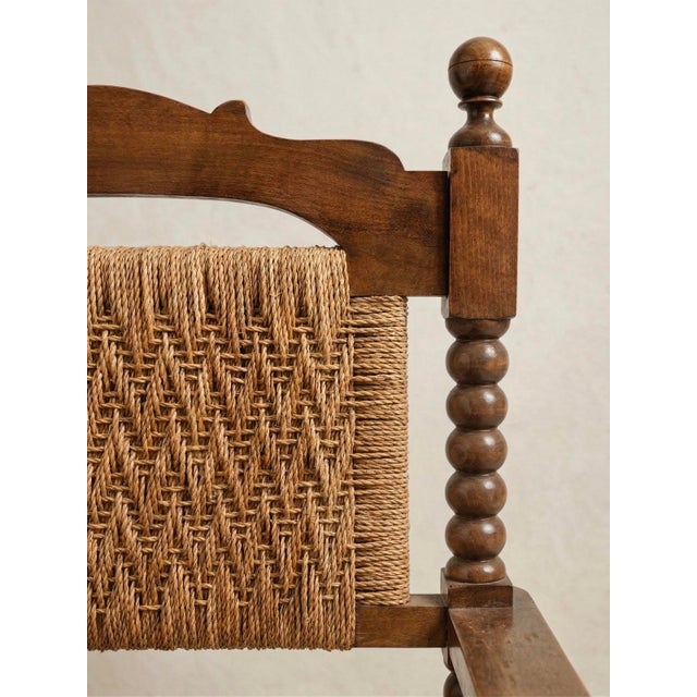 Spanish-style armchair in the Castilian style, crafted from solid wood with a woven rope seat and back, and accompanied by...