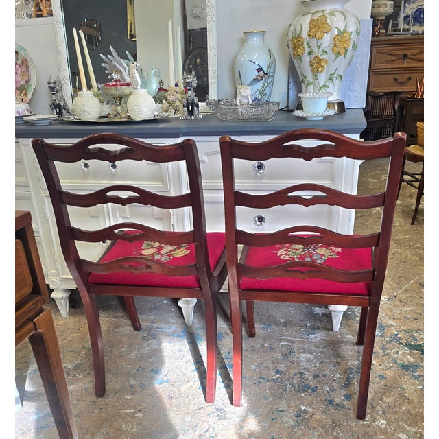 A pair of Chippendale ribbon ladderback chairs. Circa 1800"s.They both have needlepoint tapestry seats. The floral and...