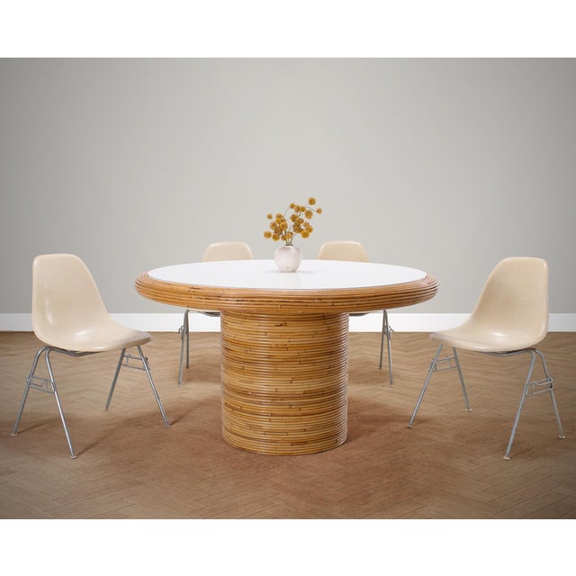 A beautifully crafted round dining table constructed from stacked pencil reed rattan in the California coastal organic...