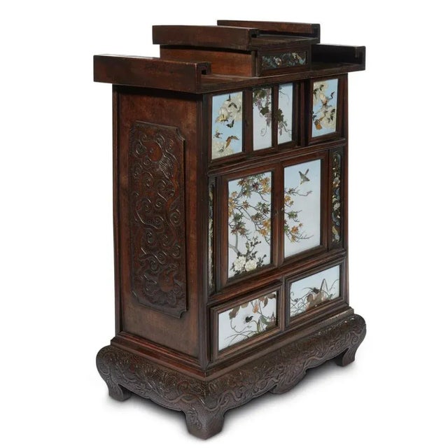 A Japanese wood and cloisonne cabinet circa Meiji period, late 19th-early 20th century. The small table top cabinet...