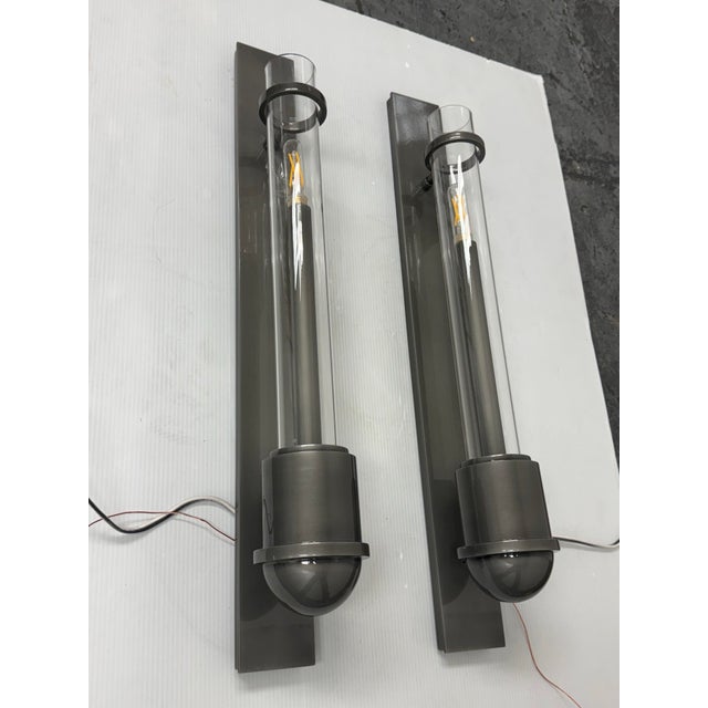Design Plus Gallery presents a Pair of the Huntley Wall Sconces from Urban Electric. The pair has a modern vertical...