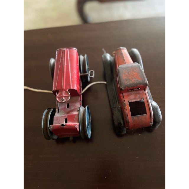 This is a vintage Marx wind up tractor likely from the early 20th century. The tractor is made of tin litho. There is a...