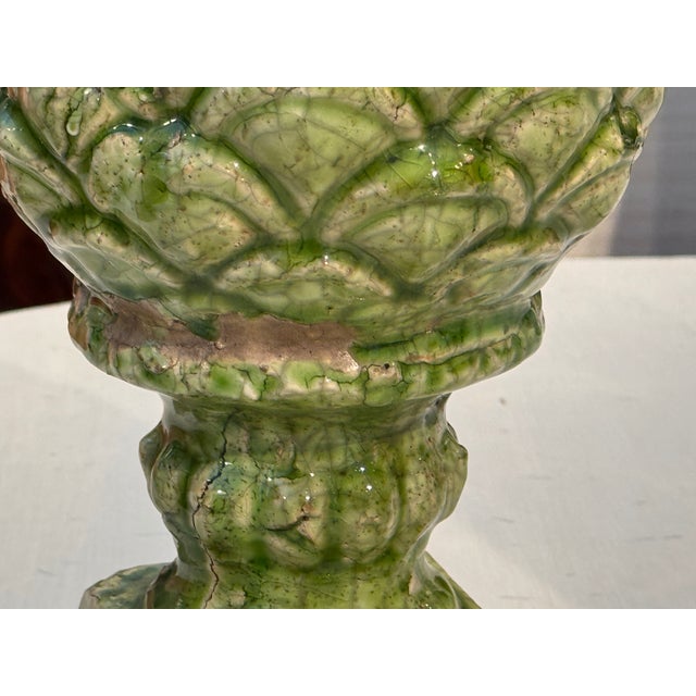 A handsome pair of glazed terracotta finials modeled as stylized artichokes, their overlapping leaves rendered in mottled...