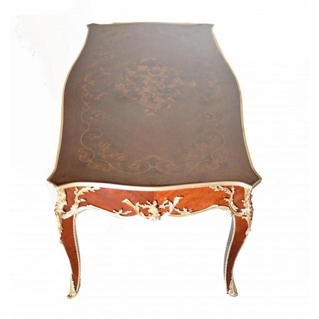 Elegant French coffee table in the Empire manner Features intricate inlay work to the top in the form of floral sprays and...