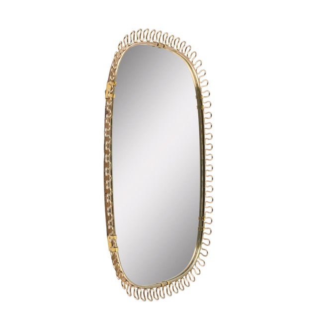 Swedish wall mirror in a brass frame with loops around the edges, designed by Josef Frank for Svenskt Tenn in the 1950s....