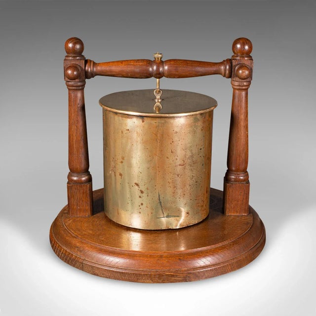 This is an antique regimental gong. A German, brass ordnance shell upon an oak base, dating to the First World War,...