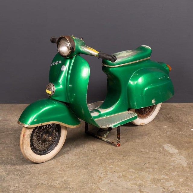 A vintage 20th century child-sized piaggio vespa pk50 from an italian fairground ride, finished in classic green. This...