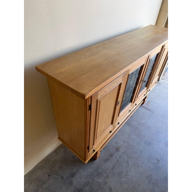 Striking Danish Brutalist sideboard crafted in solid oak, attributed to Henning Kjærnulf. This impressive piece features...