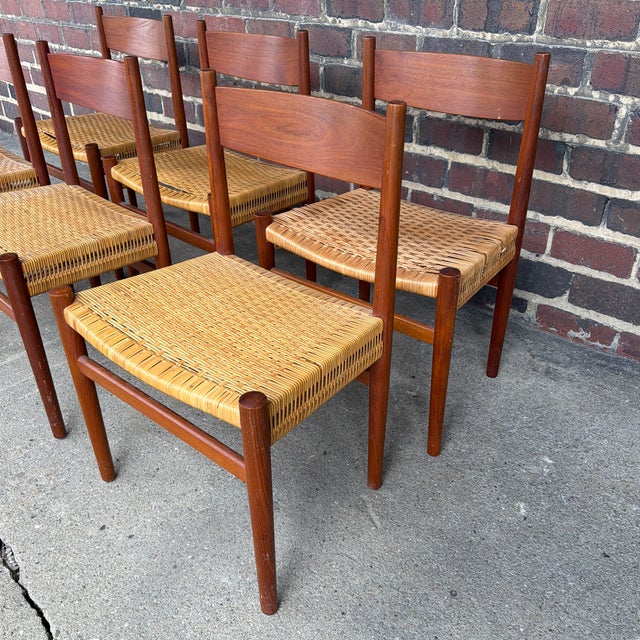 Offered is a set of six Hans J. Wegner CH-40 dining chairs, crafted in solid teak with woven cane seats. Designed with...