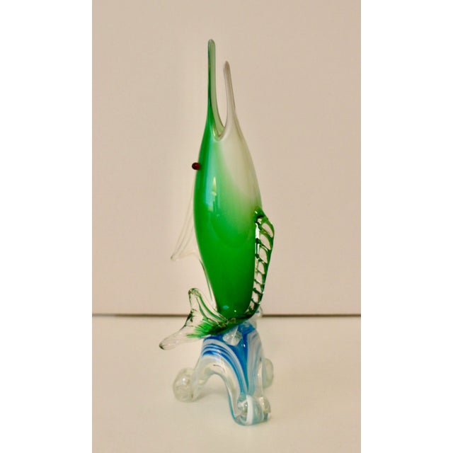 A vintage green and milky white swordfish with red eyes on a blue and white wave. Probably Italian from Murano, although...