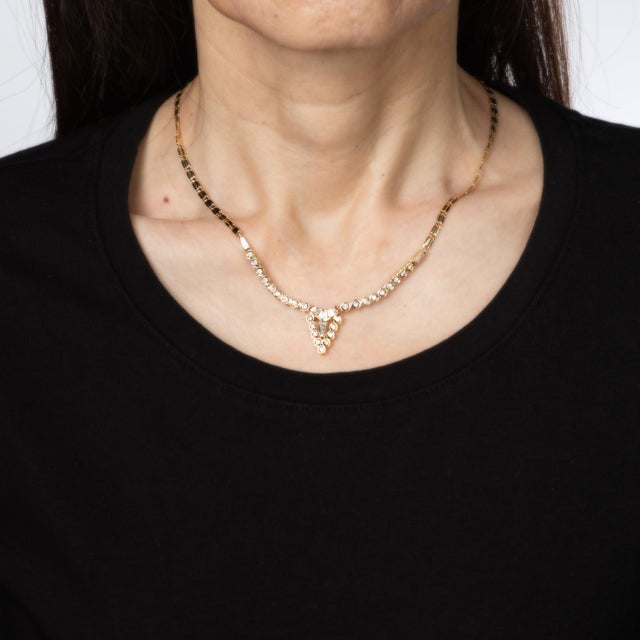 Stylish vintage diamond necklace crafted in 18 karat & 14 karat yellow gold (circa 1980s). Mixed cut baguette and round...