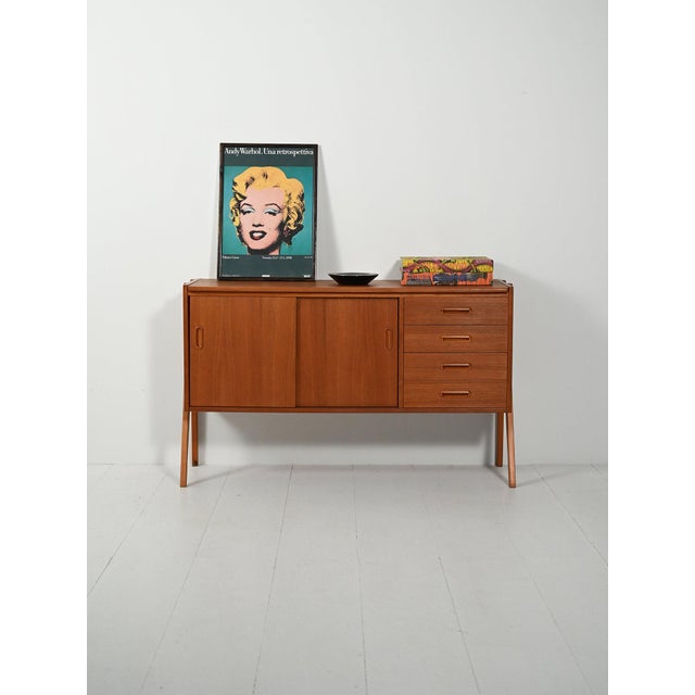 Clean lines and an exposed exterior; two compartments with sliding doors featuring oblong recessed handles and a column of...