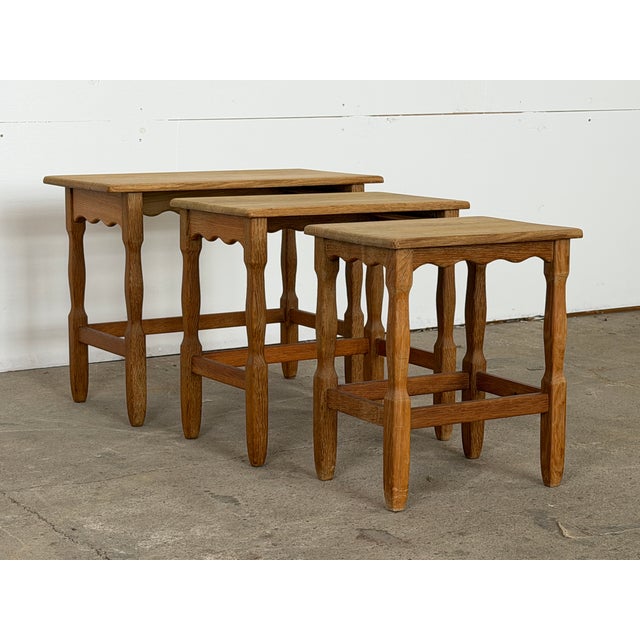 This set of three nesting tables is by Henning Kjærnulf, produced in Denmark during the 1960s. Each table is topped in...