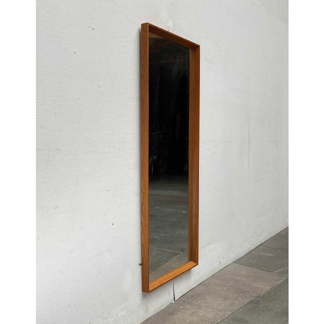 Danish wall mirror with an elegant frame made of solid teak.