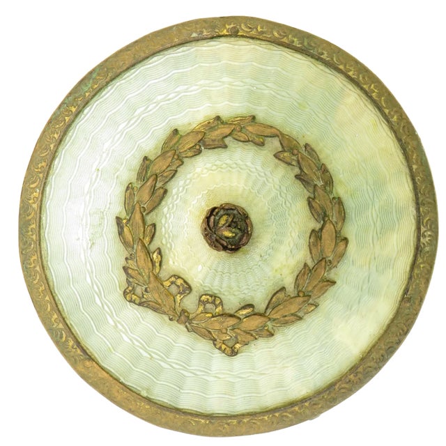 Elegant French-inspired, antique gold finish and celluloid vanity box from the early 20thC. A round container formed by a...