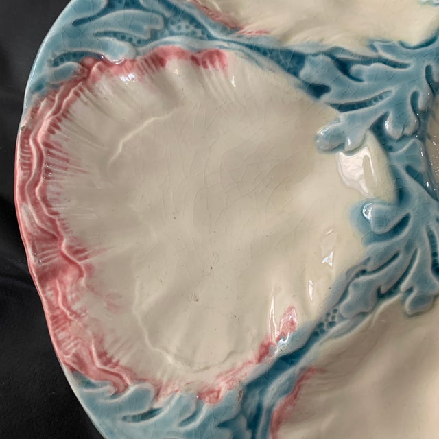A 19th-century Majolica pink and blue oyster plate, attributed to the French pottery maker Gien featuring six cream-white...