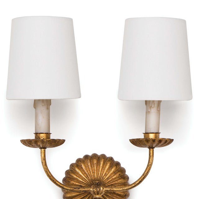 Updated opulence comes to mind with this double sconce, which wears an antique gold leaf finish on its ribbed backplate...