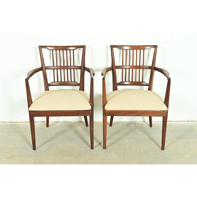 An exceptional pair of Mid-Century Modern spindle back armchairs or dining captain chairs In the manner of Paul McCobb...