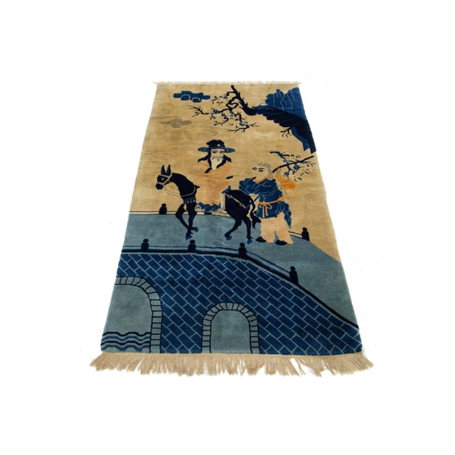 A beautiful antique Peking Chinese hand-knotted wool rug with a tan and navy blue field and orange accents throughout the...