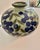 A beautifully decorative vintage ceramic vase featuring a rounded, low-profile form with a softly celadon-green glazed...