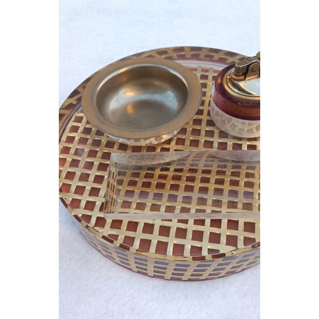 Circular methacrylate smoking set with gold-tone metal mesh, ashtray, and a built-in lighter. Made in Italy in the 1970s,...