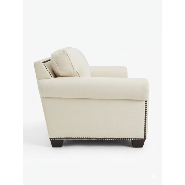 Elegant and timeless white velvet sofa featuring classic rolled arms and refined nailhead trim detailing along the base...