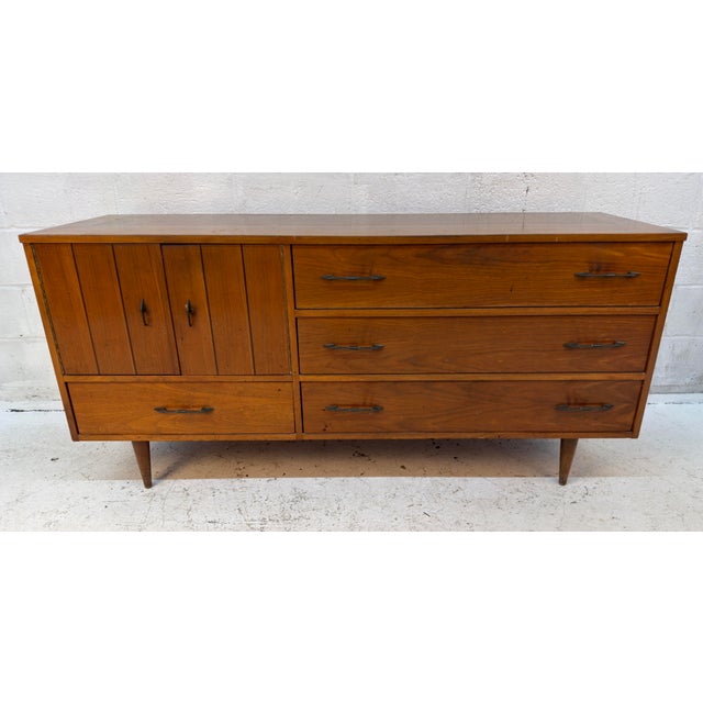 A construction of American walnut, this credenza features a rich grain across each surface and decorative metal hardware....