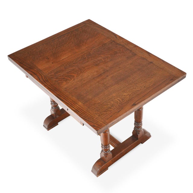 Vintage rectangular dining table made of solid oak with a dark stain and spindle base legs. It features two 11.875 in....