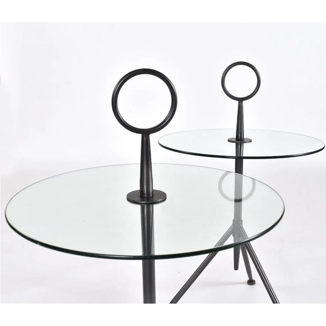 Elegant pair of round Italian modern gueridon side tables. The unique three-legged side tables have a striking sculptural...