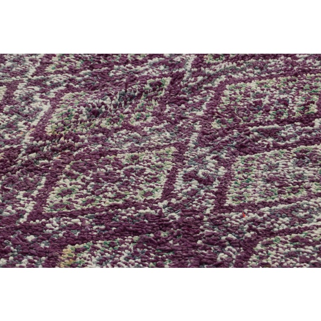 Hand-knotted in wool and originating from Morocco circa 1950-1960, this 7x10 vintage rug is a rare and among the most...