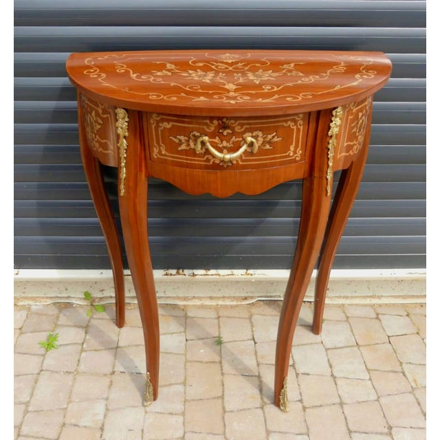 Refined and elegant, this French demi-lune side table is a timeless accent piece that showcases exceptional European...