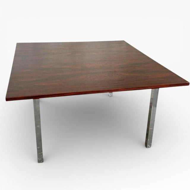 This vintage coffee table features a richly grained rosewood top paired with slim chrome legs, designed to bring a...