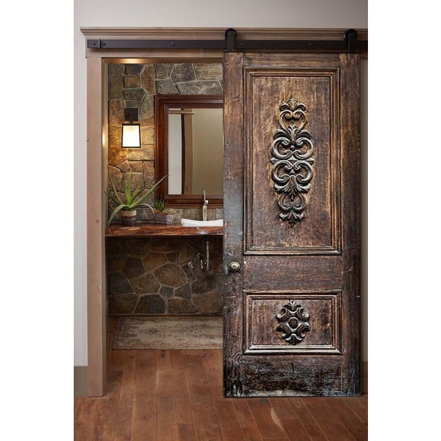 This solid wood raised-panel door features two sculpted scroll medallions arranged in a classical Baroque layout – one...