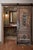This solid wood raised-panel door features two sculpted scroll medallions arranged in a classical Baroque layout – one...
