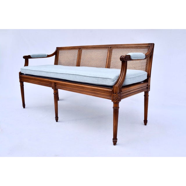 A superb Louis XVI Style Caned settee with new custom cushion in powder blue cotton upholstery. Curved hand carved...