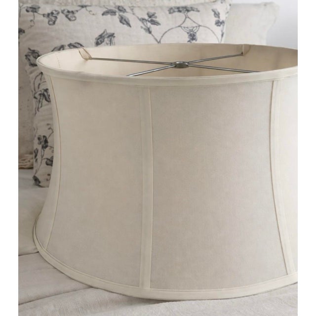 A large-scale neutral fabric lamp shade featuring a softly curved silhouette and tailored mid-century construction....